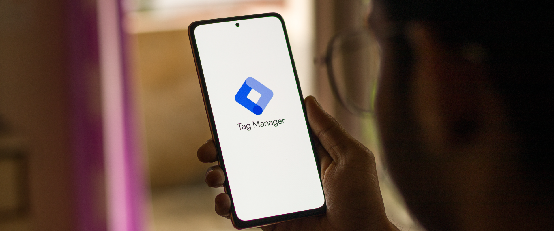 Person looking at iPhone with screen that says Tag Manager