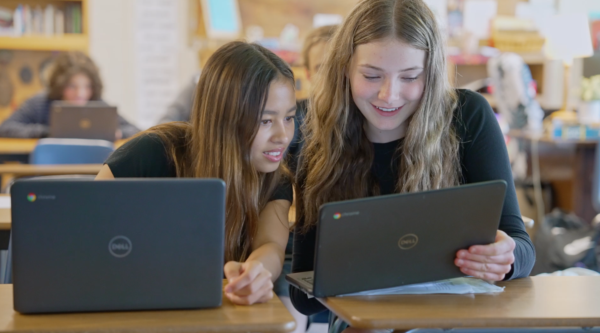 two high school students on laptops