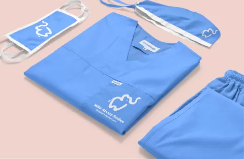 Wild About Smiles logo on scrubs, doctor hat and face mask